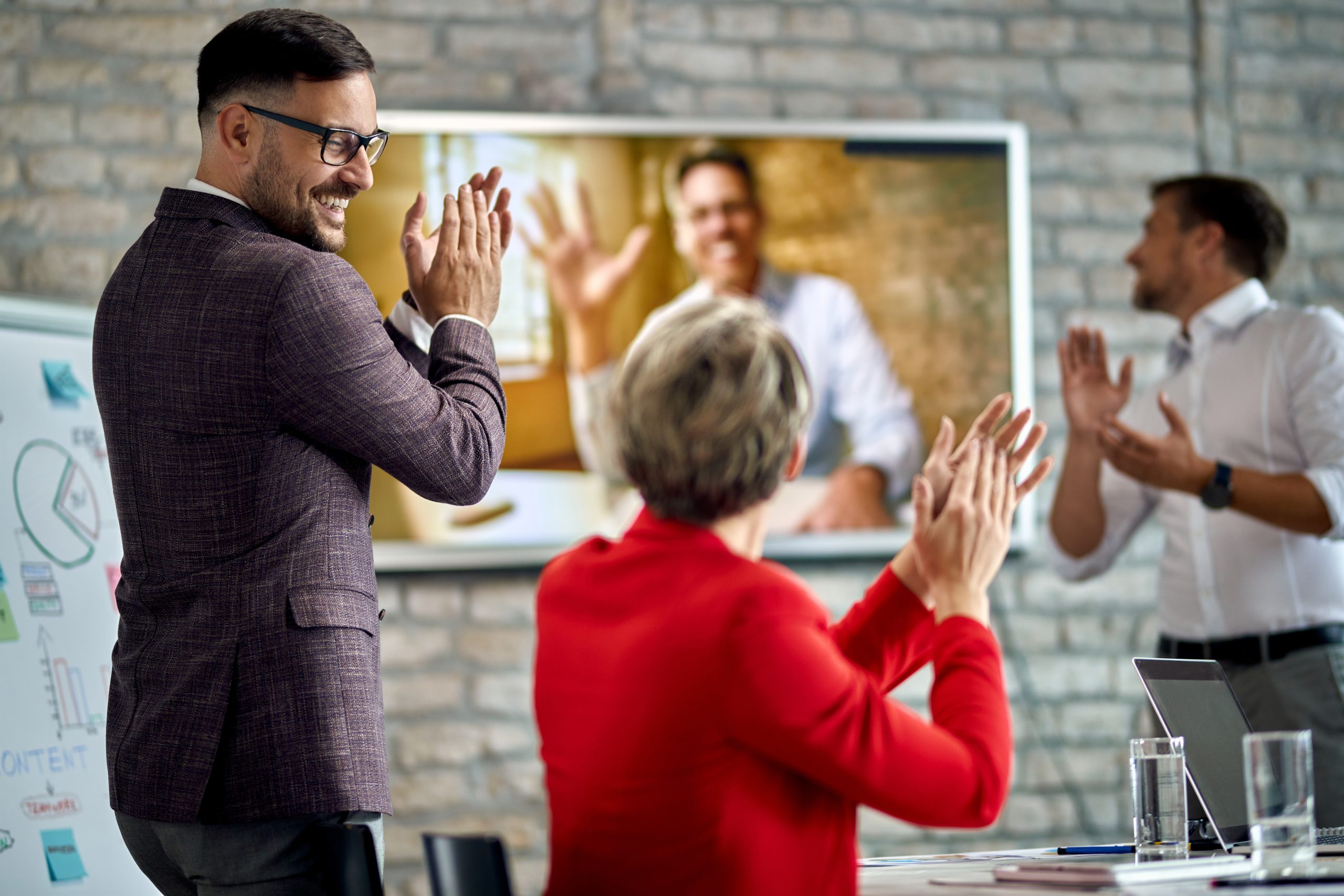 L'immagine mostra 3 persone di fronte a uno schermo dove è proiettato un software di gestione eventi
